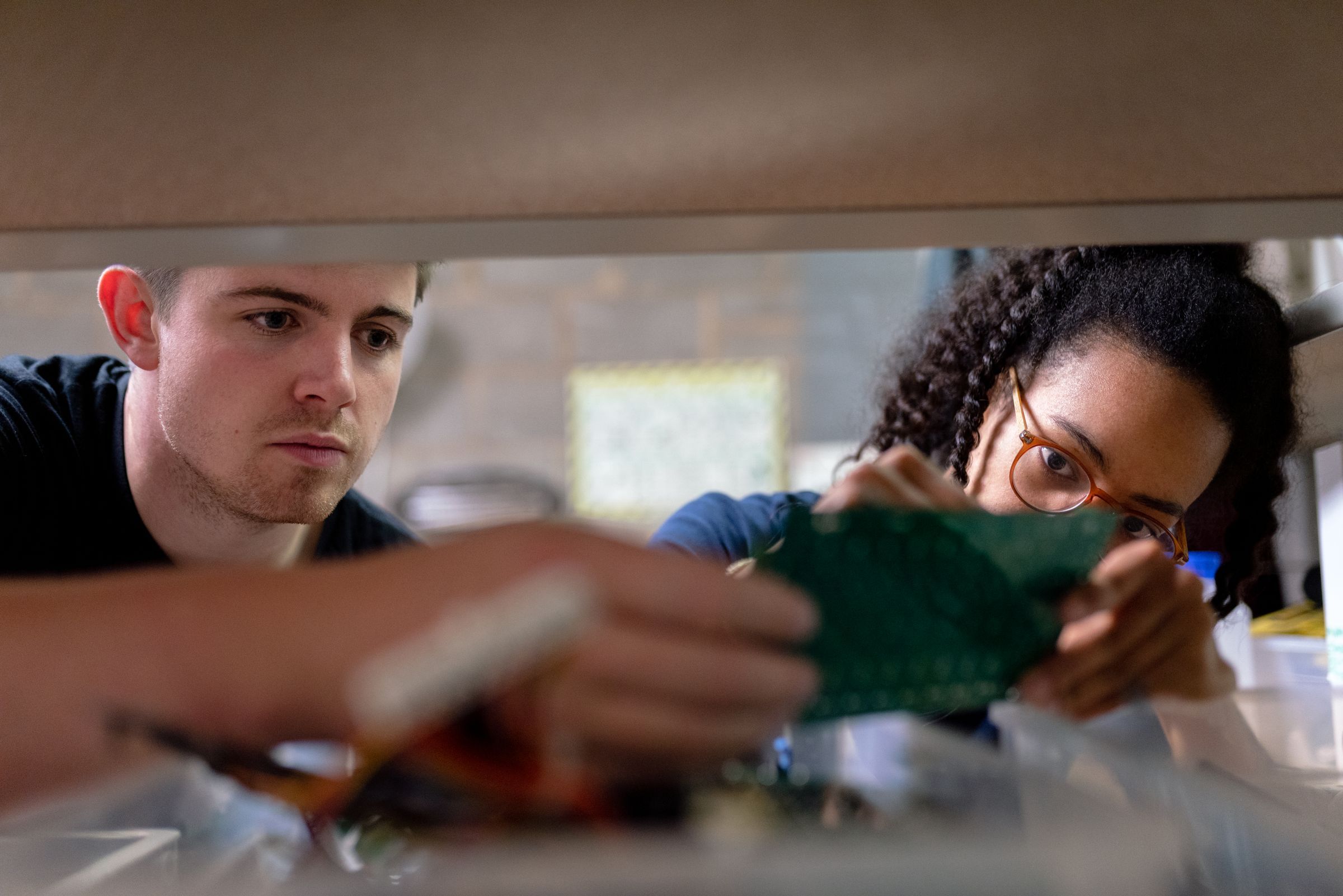 Two engineers inspecting a circuit board
